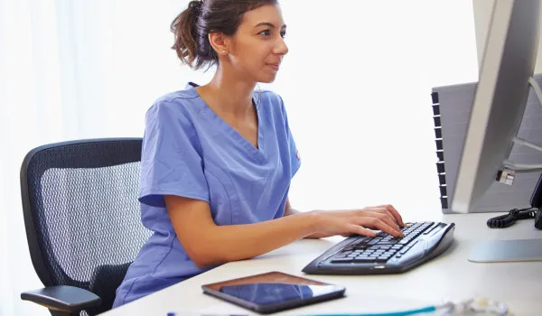 Image of nurse at computer desk