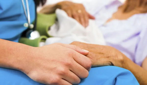 Image or nurse and patient holding hands