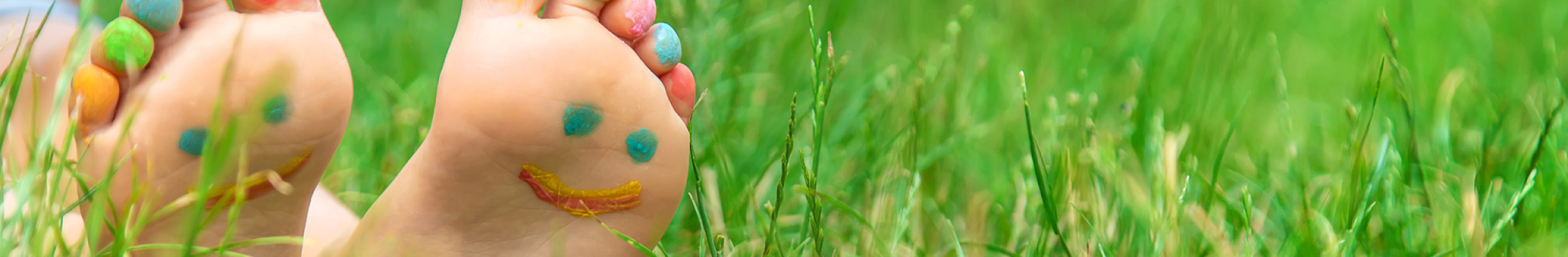 child with painted feet on grass