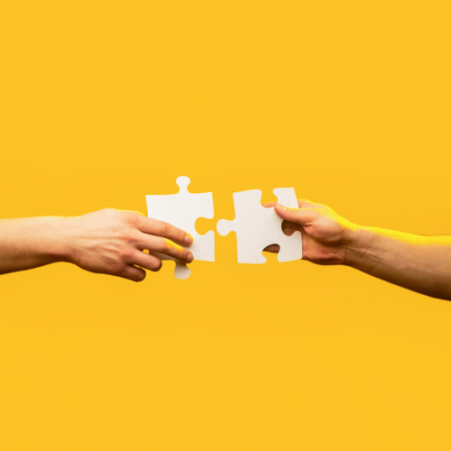 jigsaw 2 hands yellow background