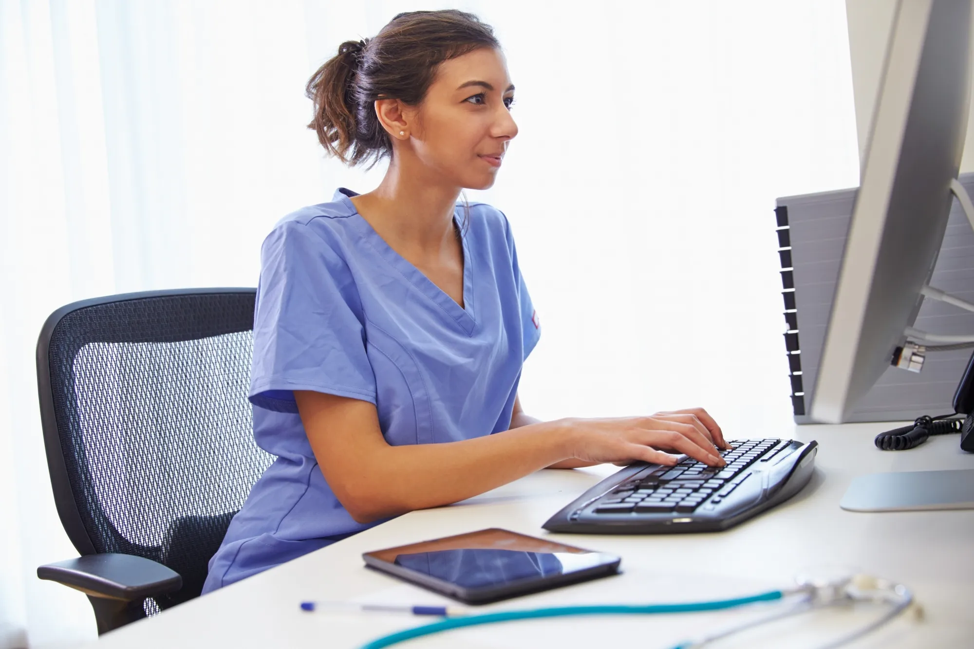 Image of nurse at computer desk